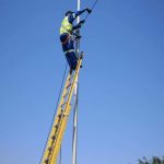 Technician working at height on a cable installation